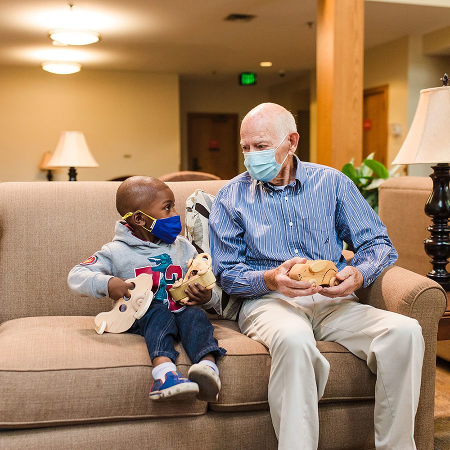 volunteer and child chatting with masks on