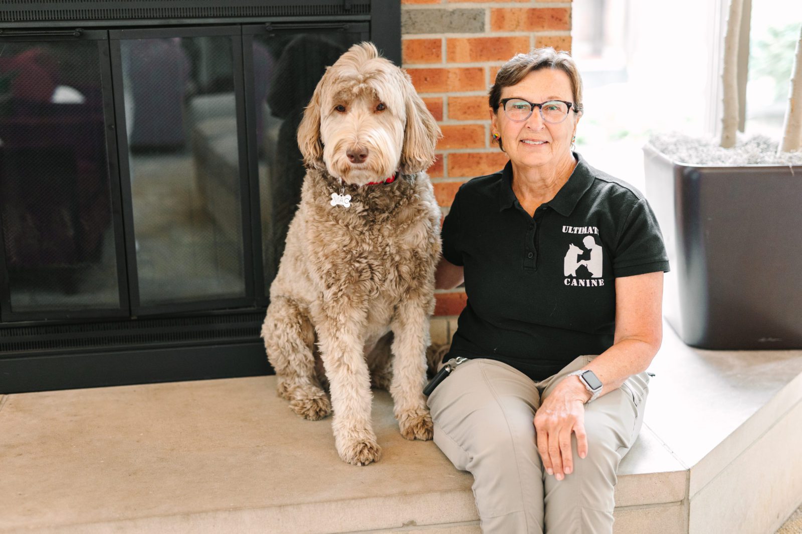 Beth Johnson smiling with Mac the therapy dog