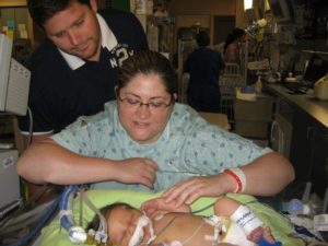 The Beckers look over their baby